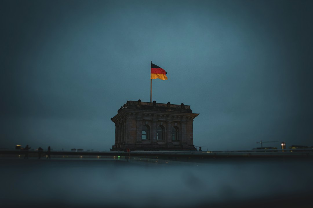 Reichstag bei Nacht – deutsche Fahne im dunklen Abendhimmel